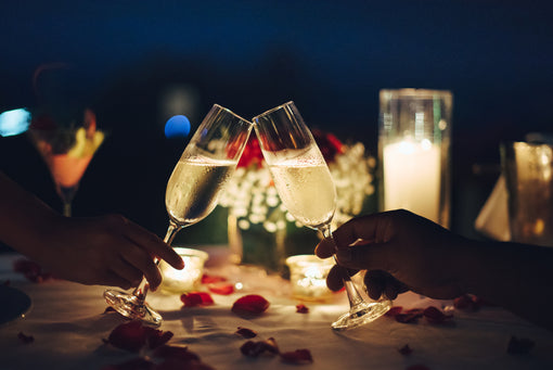 couple clinking glasses during romantic valentines candlelight dinner